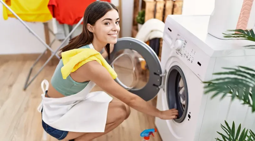 young-woman-crouched-in-front-of-washer-smiling